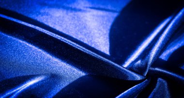 Yumuşak kıvrımlı parlak mavi kumaşın yakın çekimi zarif ve pürüzsüz dokusunu gözler önüne seriyor. Kumaşın zengin rengi ve saten kaplaması tasarım projeleri için mükemmel lüks bir estetik yaratıyor..