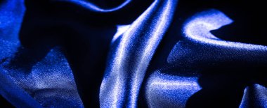 İnce röfleli koyu mavi saten kumaş, kıvrımlarının güzelliğini sergiliyor ve zarif, soyut bir tasarım ve ince dokularla ipek gibi pürüzsüz..