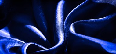 Yumuşak mavi saten kumaştan ince dalgalar ve ince röfleler, zarif parıltısını ve pürüzsüz dokusunu arttırır, zengin, parlak bir etki için kontrollü ışık altında yakalanır..