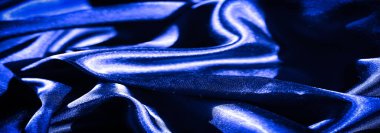 Pürüzsüz kıvrımlar ve kıvrımlar halinde akan lüks mavi saten kumaş bulanıklığı zarafet ve parlaklığın özünü yakalıyor. İpeksi dokusu ışığı ince bir şekilde yansıtıyor ve zengin bir varlık yaratıyor.