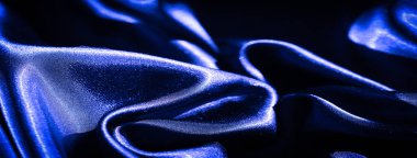 Yumuşak, dalgalı ve parlak röfleli koyu mavi kumaşlar. Zengin doku ve zarif kırışıklıklar hafif bir ışık oyunuyla dinamik, lüks bir yüzey yaratır..