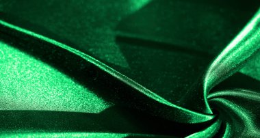 Parlak yansımaları ve pürüzsüz dalgaları olan yemyeşil saten kumaş yumuşak, akıcı dokusu ve ipeksi parıltısıyla lüks ve zarif bir görsel yaratıyor..