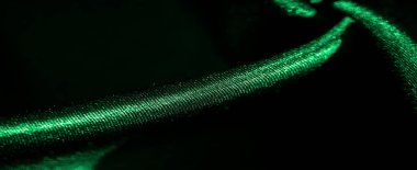 İnce kıvrımlı ve yumuşak ışıklandırmalı yeşil saten kumaş bulanıklığı. Pürüzsüz ve parlak dokuyu vurguluyor. Lüks tekstil veya moda sunumları için mükemmel..