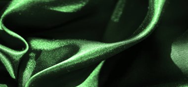 Parlak yeşil saten kumaş bulanıklığı, soyut ve akışkan şekiller oluşturuyor. Pürüzsüz, parlak doku ve yumuşak kıvrımlar yüzeyde karmaşık ışık oyunlarıyla lüks bir görsel etki yaratır..