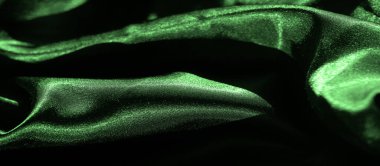 Yumuşak, dalgalı kıvrımları olan canlı yeşil saten kumaştan bir bulanıklık. Pürüzsüz dokusu ve parlak yüzeyi zarif, soyut bir ışık ve gölge görüntüsü yaratır.
