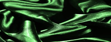 Yumuşak yeşil saten kumaş bulanıklığı, pürüzsüz, akıcı dokusunda ışığı yakalıyor. Yumuşak dalgalar ve kıvrımlar, maddenin lüks kalitesini vurgular ve zengin bir görsel etki yaratır..
