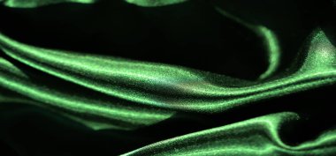 Pürüzsüz yeşil saten kumaş, dalgalanmalar ve ışık ve gölgeyle vurgulanmış yumuşak kıvrımlar. Malzemenin parıltısı akışkan, zengin dokuyu güçlendirir, lüks bir estetik yaratır..