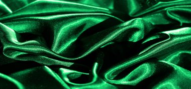 Yumuşak kıvrımlı, pürüzsüz yeşil saten kumaşın bulanıklığı, ışığı zarif ama zarif bir şekilde yansıtıyor. Zengin renk ve ipeksi doku kumaşın görünüşüne derinlik ve lüks ekler..