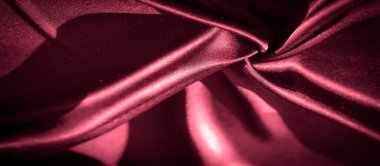 Yakından bakıldığında koyu kırmızı saten kumaş, karmaşık kıvrımlar ve yumuşak gölgeler yakalıyor, kumaşların lüks ve ipeksi dokusunu zengin, parlak bir kaplamayla renklendiriyor..