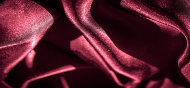 İpeksi bordo kumaş, katlanmış ve örtülmüş, parlak dokusu ve parlak parıltısı sergileniyor. Saten kumaşın derin rengi ve pürüzsüz dokusu zarafet yayar ve lüks temalar için idealdir..