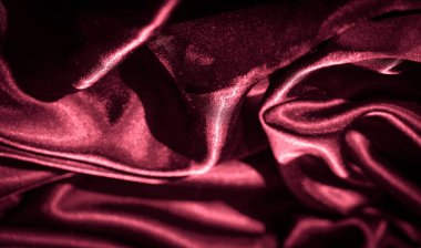 kıvrımlı ve buruşuk kırmızı satenler: Kırmızı satenin zengin, parlak dokusu ışığı zarif kıvrımlara ve ince kırışıklıklara yansıtır, göz alıcı, lüks bir hisle soyut bir tasarım yaratır.