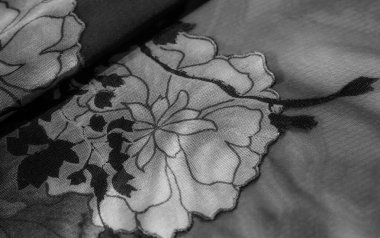 Gri tonlarda narin bir çiçek deseni bulanıklığı. Karmaşık dokuyu ve ince örgü örtüsünü vurguluyor. Kumaş kıvrımları dinamik ışık ve gölge zıtlıkları yaratır ve zarif bir estetik sunar..