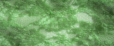 Işıl ışıl, altıgen ağ kaplamalı, metalik mor çivilerle çevrili yeşil dantelli kumaş. Bu zarif kumaş yumuşak bir doku ve lüks bir parlaklık sunuyor.