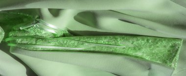 Bu canlı yeşil kumaş, bal peteği benzeri desenli hassas bir dantel dokuya sahip. Kenarında küçük, pırıl pırıl elmaslarla süslenmiş, parlak ve karmaşık bir detay kombinasyonu sunuyor.