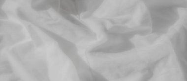 Kırışık ve kıvrımlı buruşuk beyaz kumaş. Yumuşak doku rahatlatıcı bir ortam ekler, değişken ışık ise yumuşak gölgeler yaratır, kompozisyona derinlik verir..