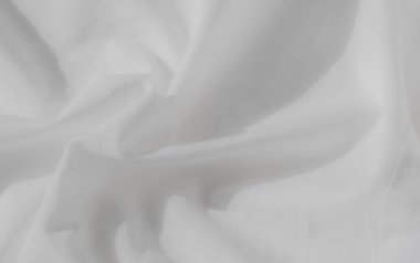 Karmaşık bir şekilde katlanmış beyaz kumaş, yumuşak dokular ve ince gölgeler. Işık ve gölge arasındaki etkileşim kumaşın pürüzsüz ve zarif yüzeyini güçlendirir. Sakin ve huzurlu bir his verir..