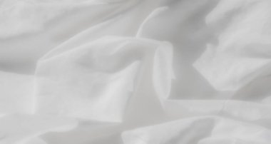 Yumuşak, akışkan kıvrımları ve pürüzsüz bir dokusu olan beyaz kumaş bulanıklığı. Kumaştaki ışık ve gölge oyunu, minimalist, rahatlatıcı estetiğine derinlik katar, arka plan için mükemmeldir..