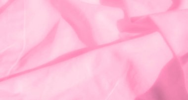 Karmaşık kıvrımları olan yumuşak pembe kumaş bulanıklığı narin ve kadınsı bir atmosfer yaratıyor. Pastel tonlar ve pürüzsüz doku sıcaklık ve zarafet hissi verir..