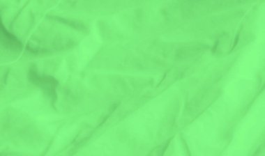 Karmaşık kıvrımları ve yumuşak röfleleri olan bulanık yeşil kumaş, ince dokular ve ışık yansımaları ile hayali, soyut bir görsel oluşturur. Genel etkisi ruhani ve sakindir..