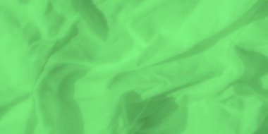 Yumuşak, örtüşen dalgalar ve yumuşak kırışıklıklarla dolu canlı yeşil kumaşın bulanık soyut kıvrımları sakin ve akışkan bir etki yaratıyor. Yumuşak dokusu ışığı incelikle yansıtıyor, rüya gibi bir ortam ekliyor.