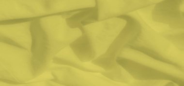 Doğal kıvrımlara ve kıvrımlara odaklı yumuşak sarı kumaş bulanıklığı. Akan madde ışığı ince bir şekilde yansıtır ve tasarım için sıcak ve davetkar bir doku yaratır..