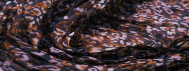 Karmaşık kırmızı, siyah ve beyaz soyut desenli yumuşak kumaş bulanıklığı. Tasarım dinamik görünüyor, canlı renkler maddenin içinde pürüzsüz bir şekilde harmanlanıyor..