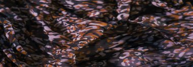 Karmaşık kırmızı, siyah ve beyaz motifler pürüzsüz, katıksız bir kumaş üzerinde. Katmanlı tasarım, karmaşık bir renk ve doku karışımı oluşturan dönen desenleri vurgular..