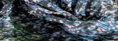 Mavi, beyaz ve yeşil tonlarda dinamik kıvrımlarda yakalanan soyut kamuflaj desenleri olan eşsiz bir kumaş bulanıklığı. Renklerin karışması görsel olarak çekici bir doku yaratır.