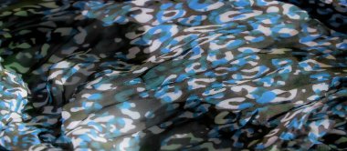 Siyah bir tabanda yeşil, mavi ve beyaz karışımıyla soyut kumaş desenini bulanıklaştırarak dinamik ve akışkan bir etki yaratırız. Kumaşın dokusu yumuşak ve şekilleri düzensiz..