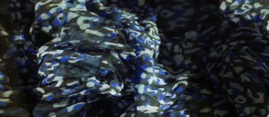 Mavi, yeşil ve beyazın canlı bir kombinasyonunu koyu renk bir arkaplana karşı bulanıklaştırır. Zengin soyut tasarım, modern yaratıcı projeler için ideal hale getiren kumaşın yumuşak akışıyla yumuşar..