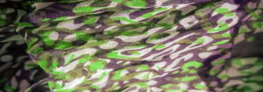 Bulanık, yumuşak kumaş dokusunda akan yeşil ve siyah soyut şekillerin akışkan bir kombinasyonu hareket ve derinlik hissi yaratır. Pürüzsüz tasarım kumaşın zarafetini arttırır..