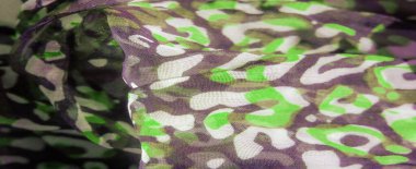 Bulanık, soyut yeşil ve koyu desenler yumuşak, akan bir kumaşa yayılmış. Organik şekiller uyum içinde harmanlanarak, derinlik, hareket ve sanatsal akışkanlık hissi ekliyor..