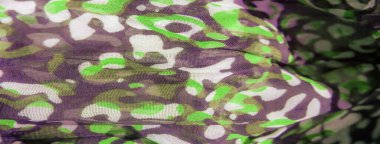 Görüntü, canlı yeşil ve koyu soyut desenler dokulu bir kumaş boyunca hareket ve enerjiyi yakalıyor. Yumuşak şekillerin etkileşimi malzemeye derinlik ve tarz katan bir sıvı tasarımı yaratır.