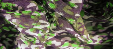 Görüntü, yeşil ve siyah soyut desenlerin canlı bir karışımı hassas bir kumaş üzerinde akıyor. Tasarım, kumaşın akıcılığını ve derinliğini yakalıyor, dinamik ve şık bir görsel deneyim yaratıyor..