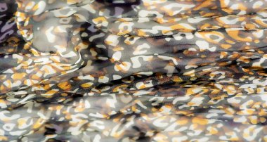 Mor, sarı ve kahverengi kıvrımlı karışımlı canlı soyut kumaş bulanıklığı. Buruşuk doku, yaratıcı ve tekstil projeleri için mükemmel, dinamik ve akıcı bir görünüm ekler..