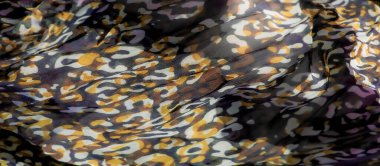 Mor, yeşil ve kahverengi tonlarında eşsiz bir soyut deseni olan bulanık kumaş. Kumaştaki akışkan dalgalar ve kıvrımlar bir hareket hissi yaratır ve genel görsel etkiyi arttırır..