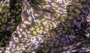 Mor, yeşil ve kahverengi renklerin karışımını gösteren bulanık kumaş eşsiz bir tasarım yaratıyor. Kumaşın dalgalı dokusu ve kıvrımları akıcılık ve zarafeti çağrıştırıyor..