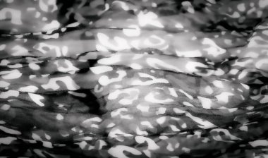 Siyah beyaz bulanık kumaş, soyut, organik desenler, hayvan izlerini çağrıştırıyor. Kumaşın dokusu ve kıvrımları tasarıma derinlik ve karmaşıklık ekler ve görsel olarak büyüleyici bir şey yaratır.