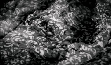 Çarpıcı siyah-beyaz soyut kumaş tasarımının bulanıklığı, kumaş hareketini ve dokusunu vurgulayan ince kıvrımlı kıvrımlar. Karşıtlık, aydınlık ve karanlık arasında dinamik bir etkileşim yaratır.