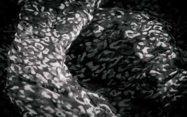 Yumuşak kumaş üzerindeki karmaşık siyah ve beyaz desenler organik formları taklit eden dalgalı bir doku yaratıyor. Işık ve gölge, maddenin dinamik ve akışkan doğasını geliştirir..