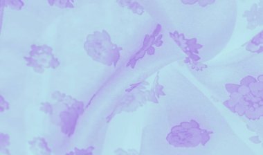 Bulanık etki, açık mavi kumaştaki yumuşak mor çiçek desenlerini vurgular, bu tekstil dokusunun romantik çekiciliğini ve nazik dokusunu arttıran dingin, zarif bir dokunuş ekler..