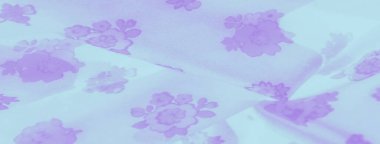 Yumuşak, şeffaf kumaş renginde, narin çiçek desenleriyle süslenmiş. Açık mor çiçekler pürüzsüz dokuyu örtüyor, nazik ve rahatlatıcı bir görsel etki yaratıyor..