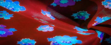 Pürüzsüz kırmızı kumaş. Parlayan mavi ve mor çiçek desenleri. Yumuşak dokular ve kalın çiçek desenleri modern tekstil tasarımları için mükemmel bir karşıtlık yaratır..