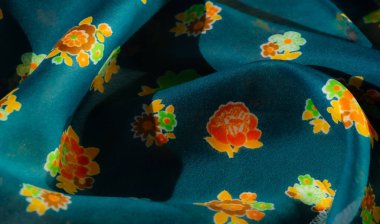 Bu kumaş görüntüde turkuaz arka planda turuncu, sarı ve yeşil çiçek desenleri var. Saf doku, havadar bir katman ekler..