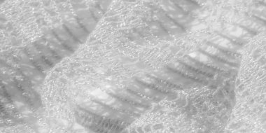 Beyazlı ince dantel kumaş bulanıklığı yumuşak dokusunu ve karmaşık detaylarını gözler önüne seriyor. Kumaşın hafifliği ve parıltısı, genel manevi kaliteye katkı sağlar..