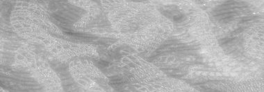 Beyazlı ince dantel kumaş bulanıklığı yumuşak dokusunu ve karmaşık detaylarını gözler önüne seriyor. Kumaşın hafifliği ve parıltısı, genel manevi kaliteye katkı sağlar..