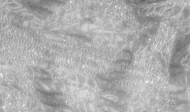 Yumuşak beyaz dantel kumaştan bulanık, karmaşık dokumalar ve ince dokular var. Dantelin narin tasarımı ışığın yansımasıyla güçlenir, parıldayan, havadar bir kalite ekler..