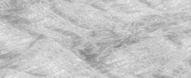 Yumuşak beyaz dantel kumaştan ince kıvrımlar halinde bulanık, parıldayan detaylarını ve karmaşık desenlerini yakalıyor. Kumaşla olan ışık etkileşimi onun lüks ve rüya gibi görünümünü arttırır.