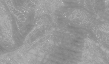 Beyaz dantel kumaştan ince, parlak detaylar, zarif dalgalar halinde akıyor. Yumuşak doku ve karmaşık desen ışıkla güçlendirilmiş zarif ve lüks bir görünüm yaratır..