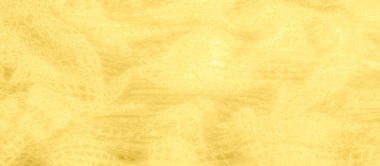 Işıldayan yüzeyi olan sarı kumaş bulanıklığı, dinamik ışık yansımaları yaratıyor. Kumaşın kıvrımları ve dokusu soyut dalgalar oluşturur, hareket ve akıcılık hissi verir..